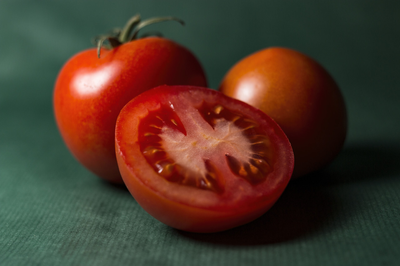tomatoes sliced on green background