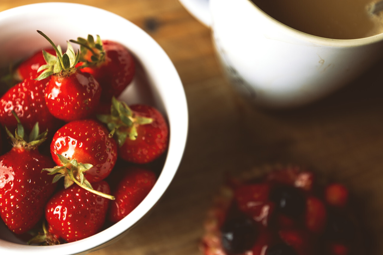 bowl of strawberries with coffee and cake