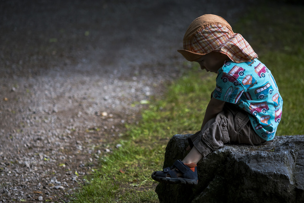 child is sitting on a rock