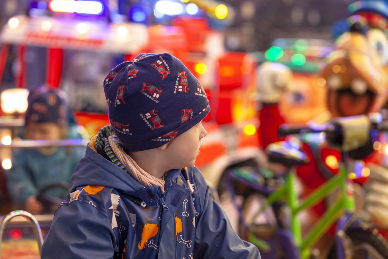 Child on a carousel with cars at a Christmas market in Germany