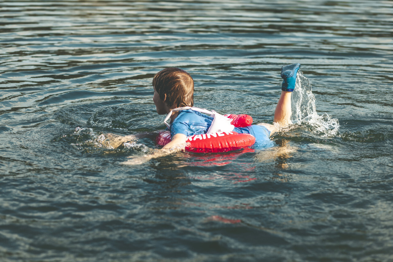 child is swimming in the lake