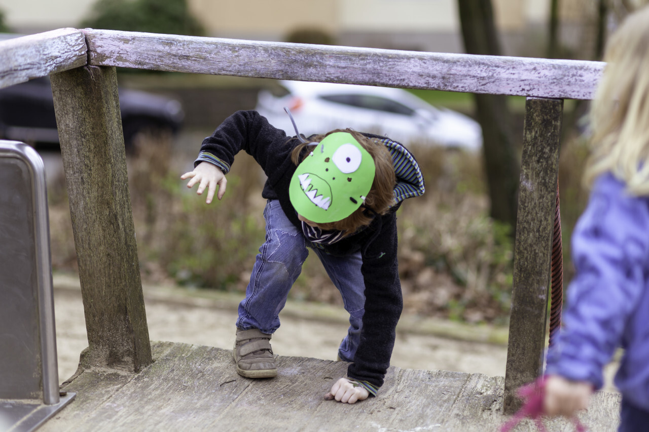 boy with monster mask playing on playground