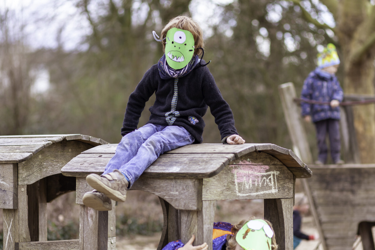 boy with monster mask playing on playground