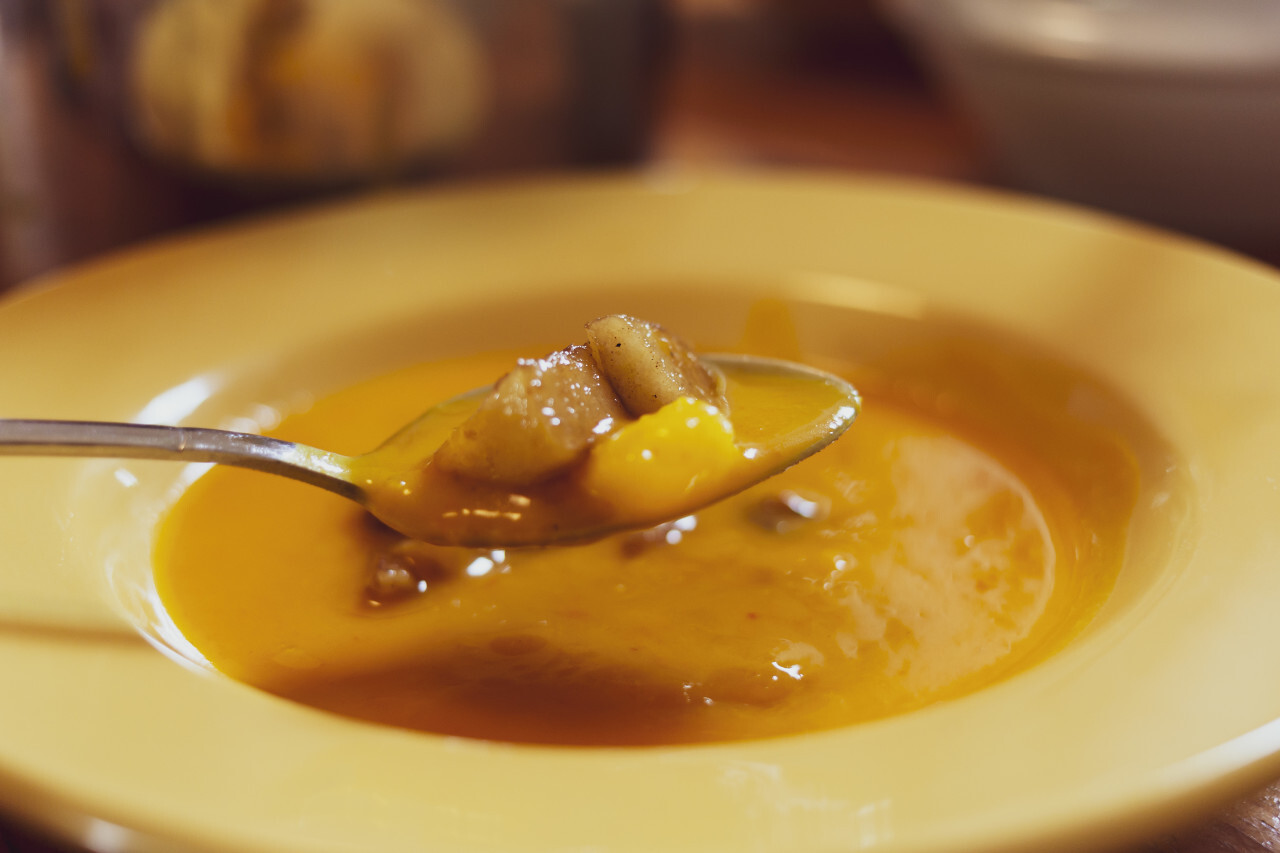 pumpkin soup on a yellow plate or bowl