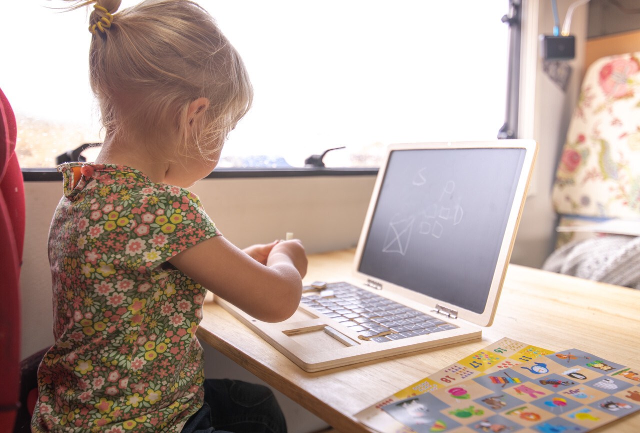 Little girl plays with toy notebook