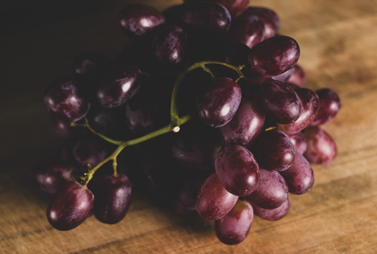 red grapes on a wooden board in a kitchen
