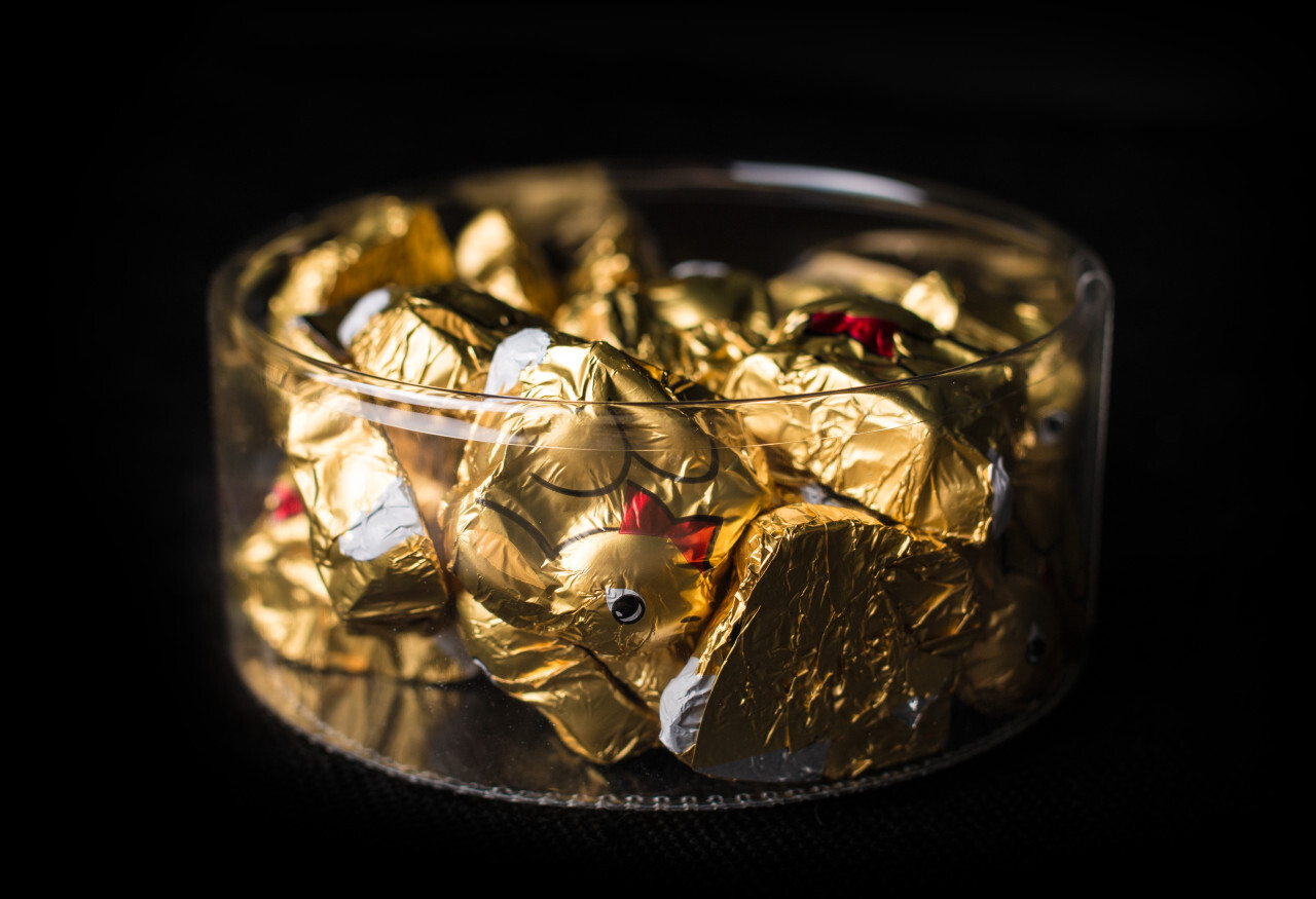 gold wrapped chocolate easter bunny isolated on black background