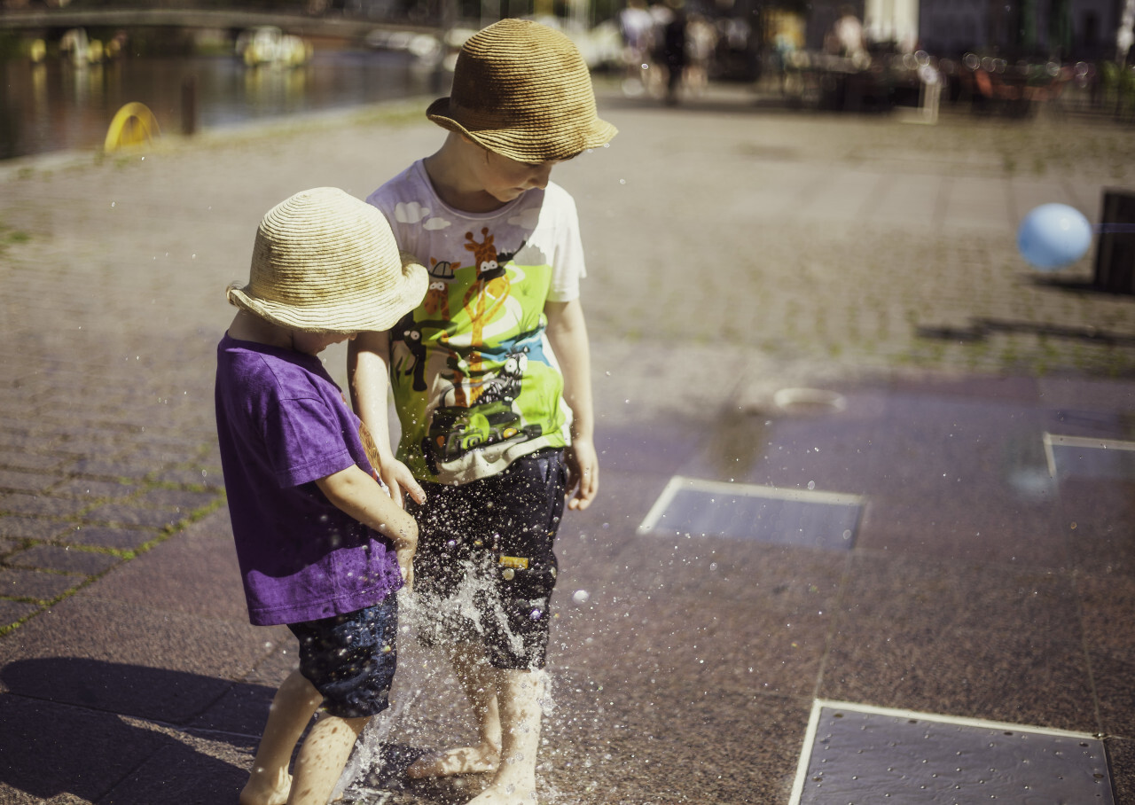 children play at the fountain