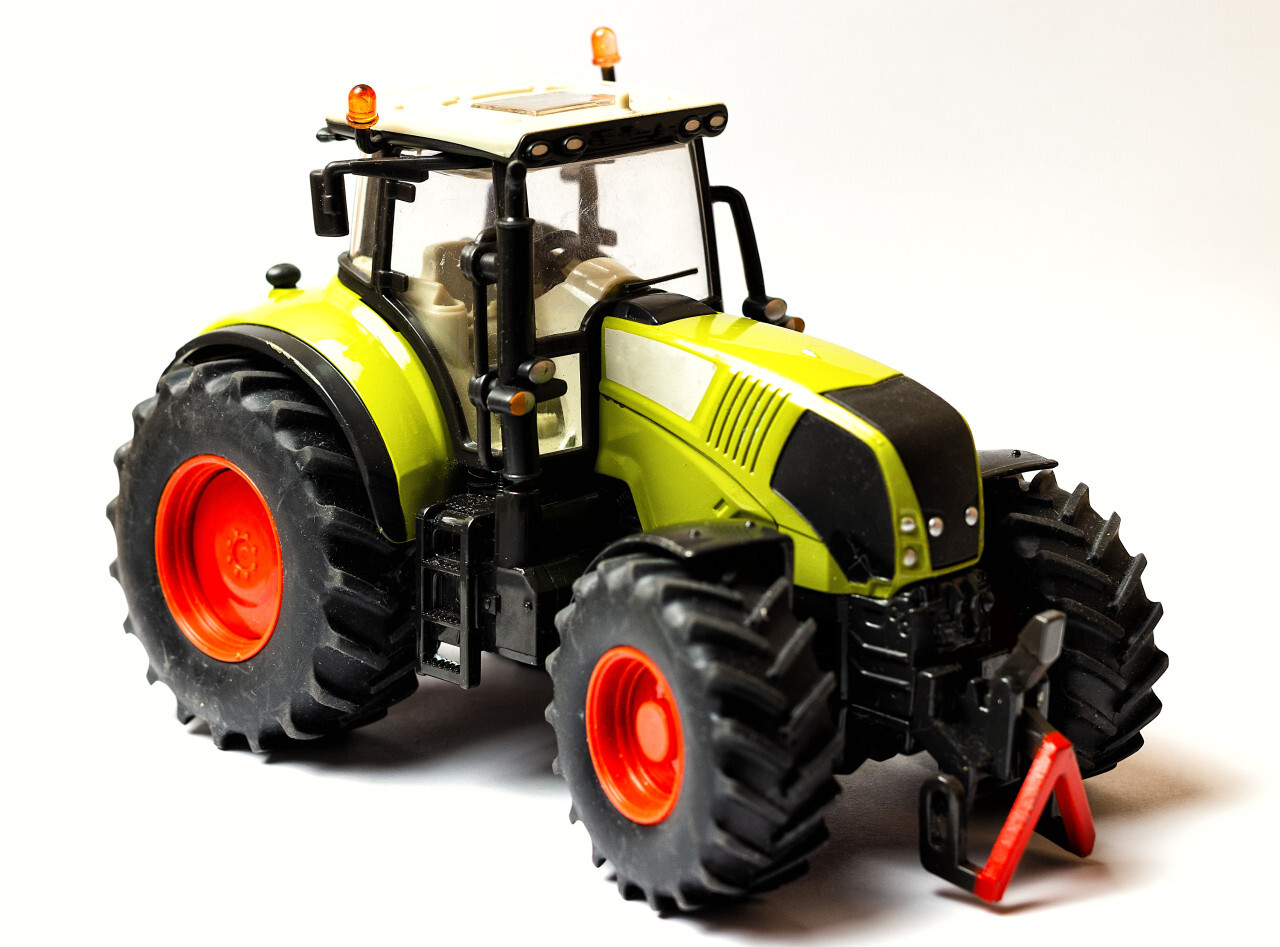 green toy tractor white background