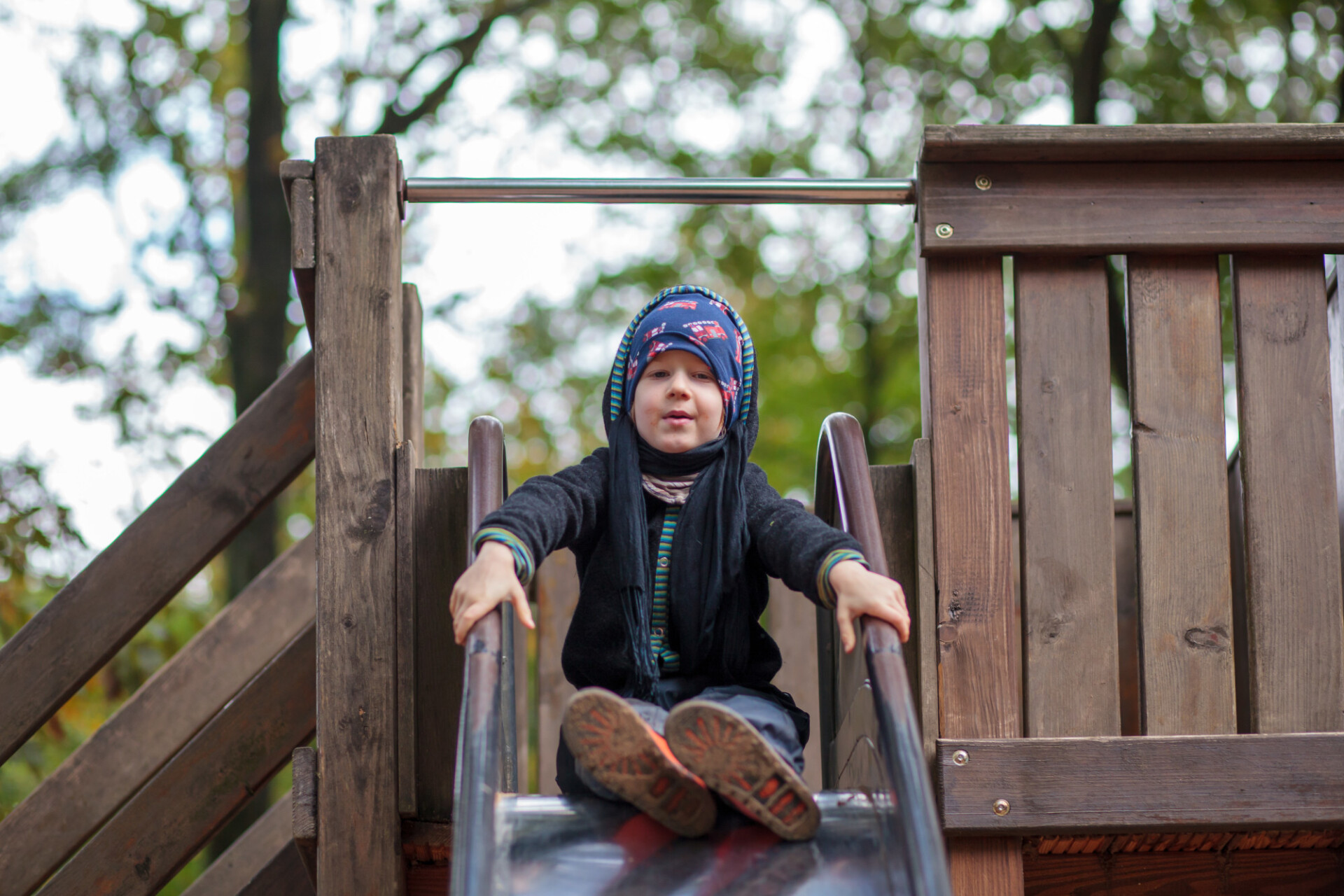 Little boy in autumn on a slide