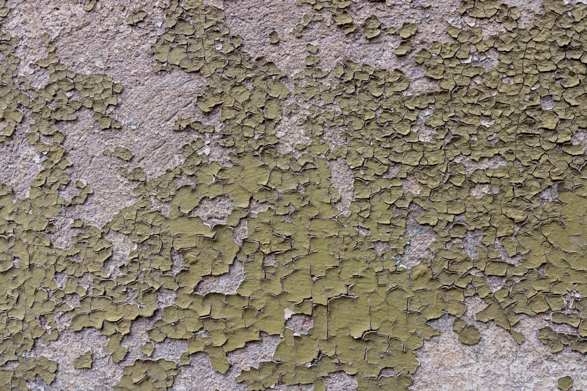 Old wall from which green paint is peeling off