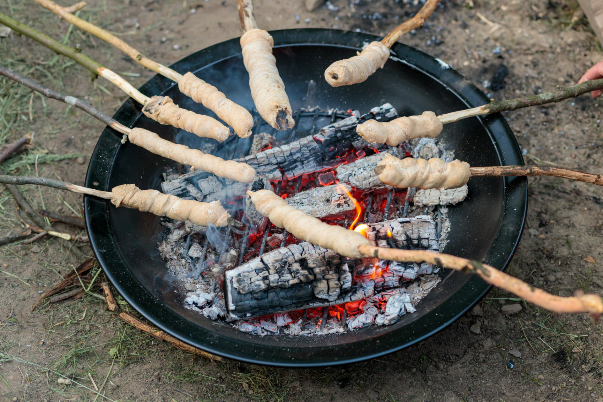 Bread on sticks is grilled over the fire