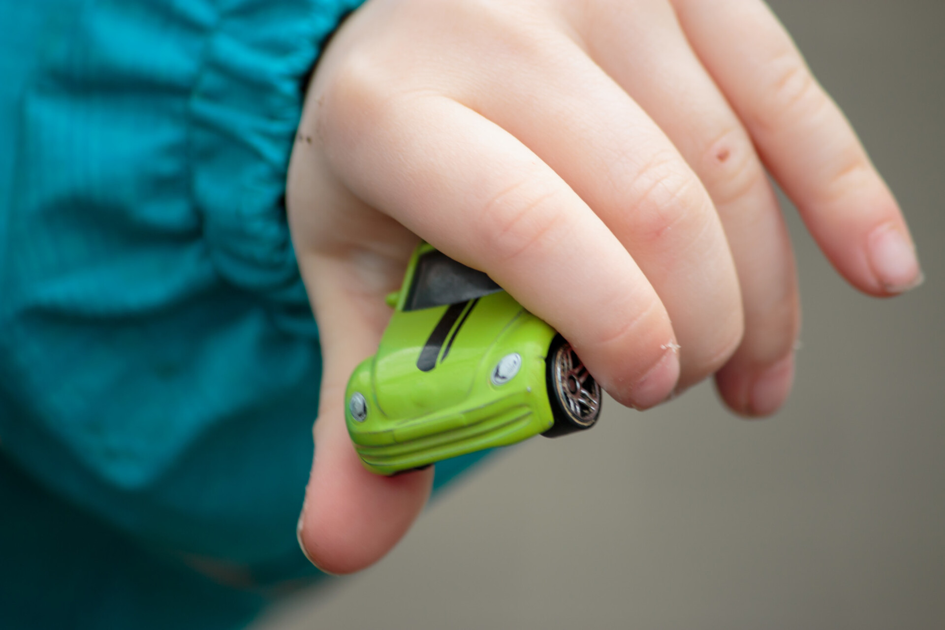 Child holding toy car in hand