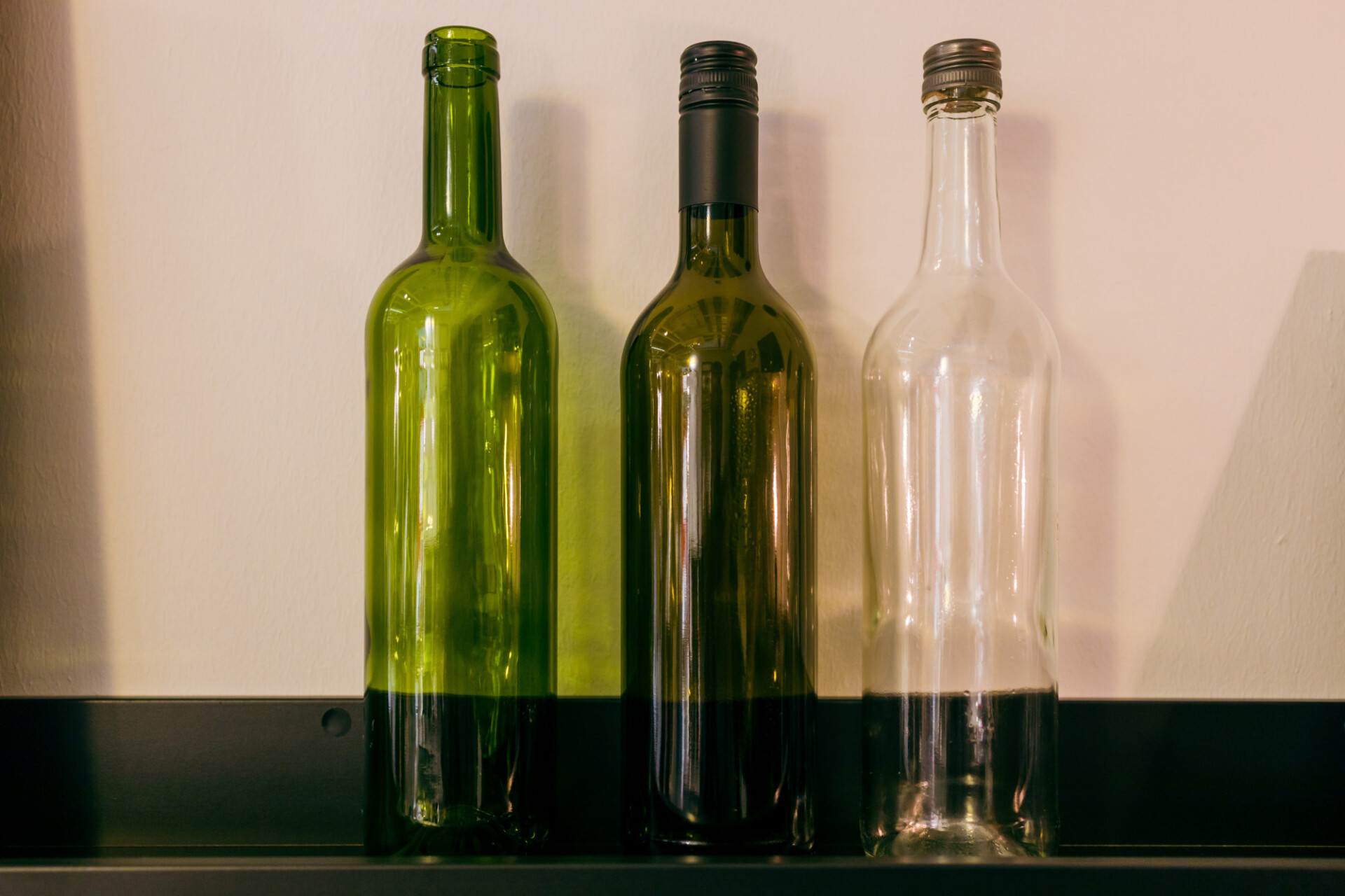 Empty wine bottles in three different shades