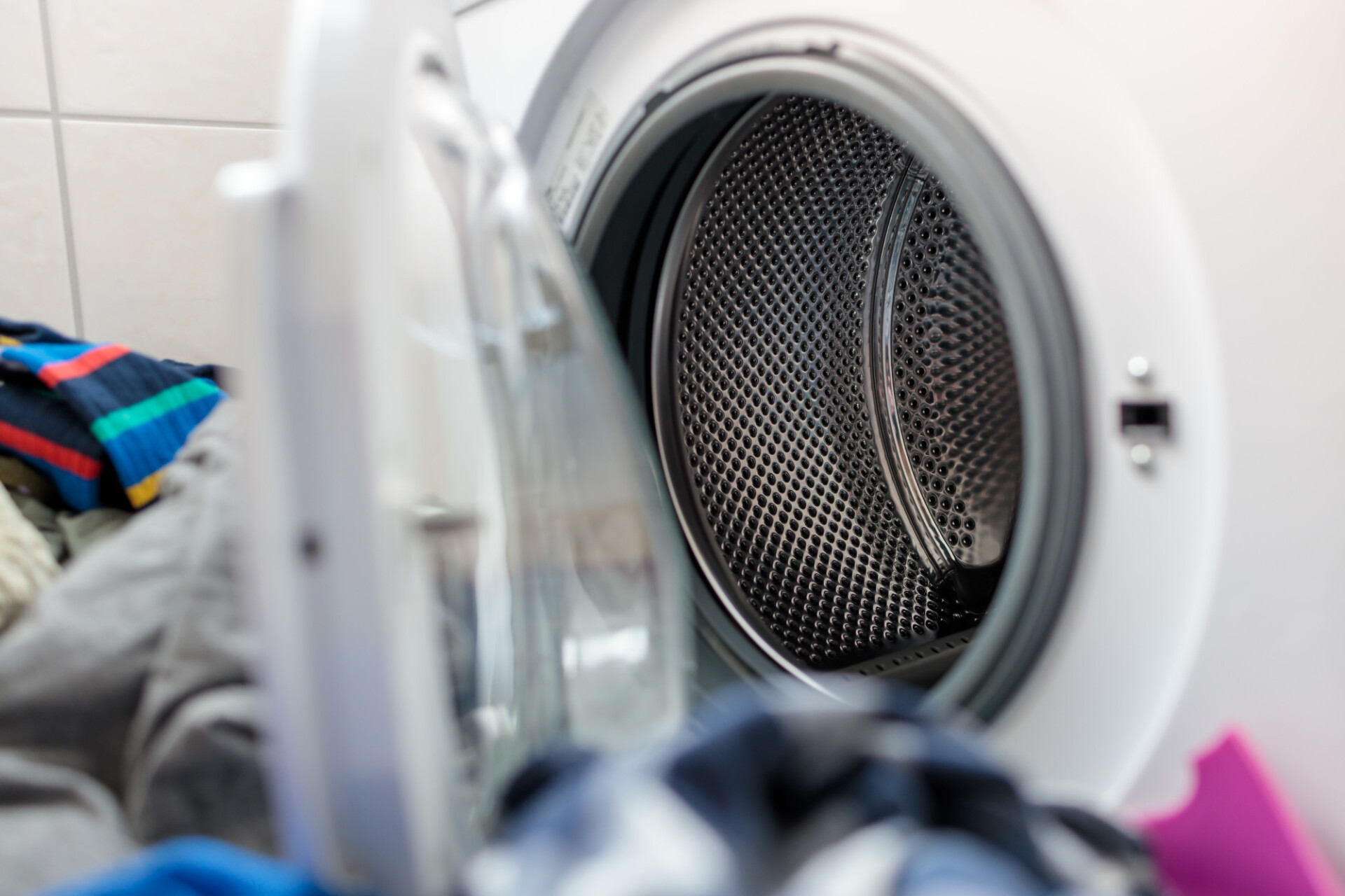 Pile of laundry in front of washing machine