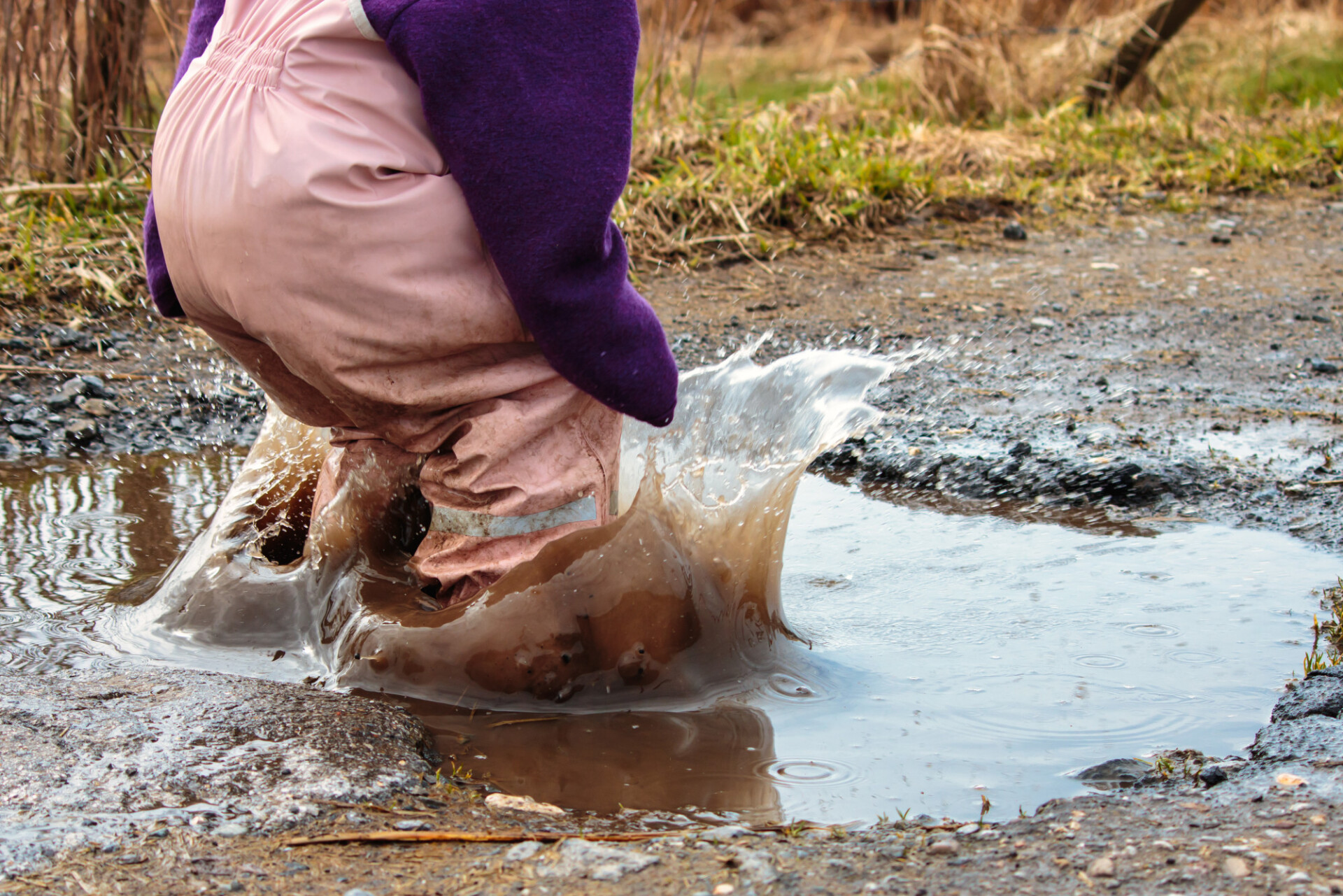 Child jumps into a puddle