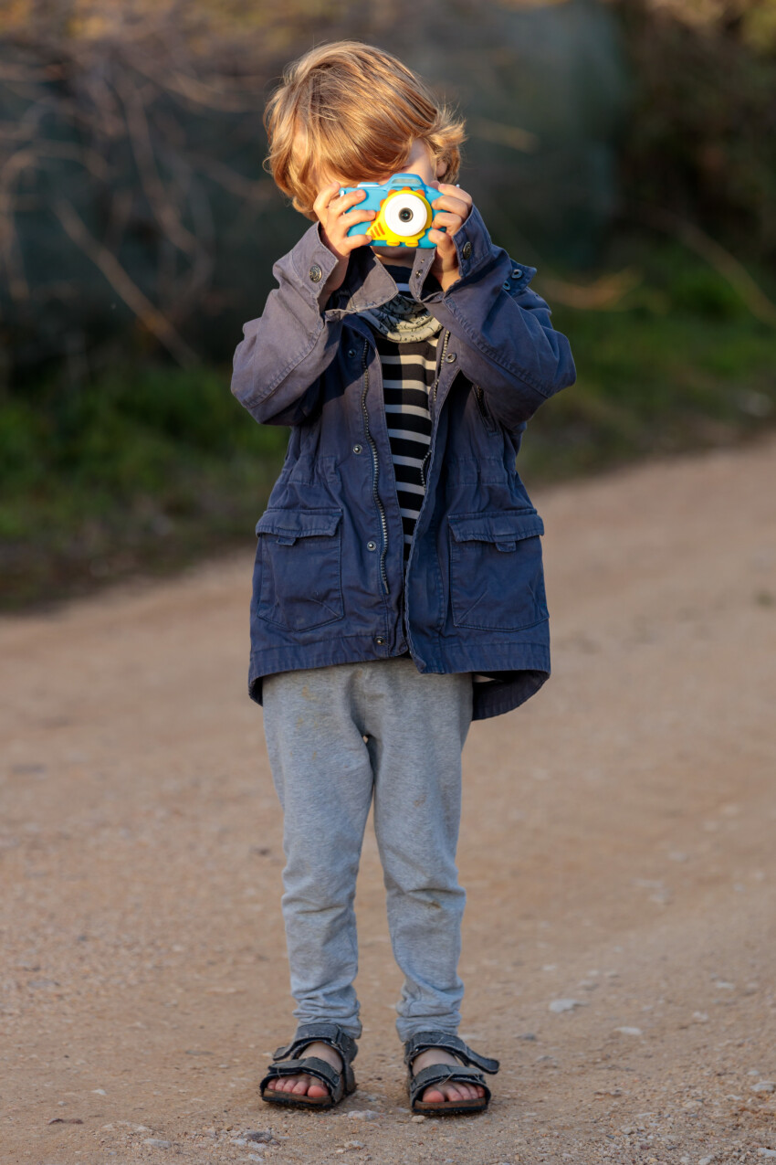 Child with camera in front of face