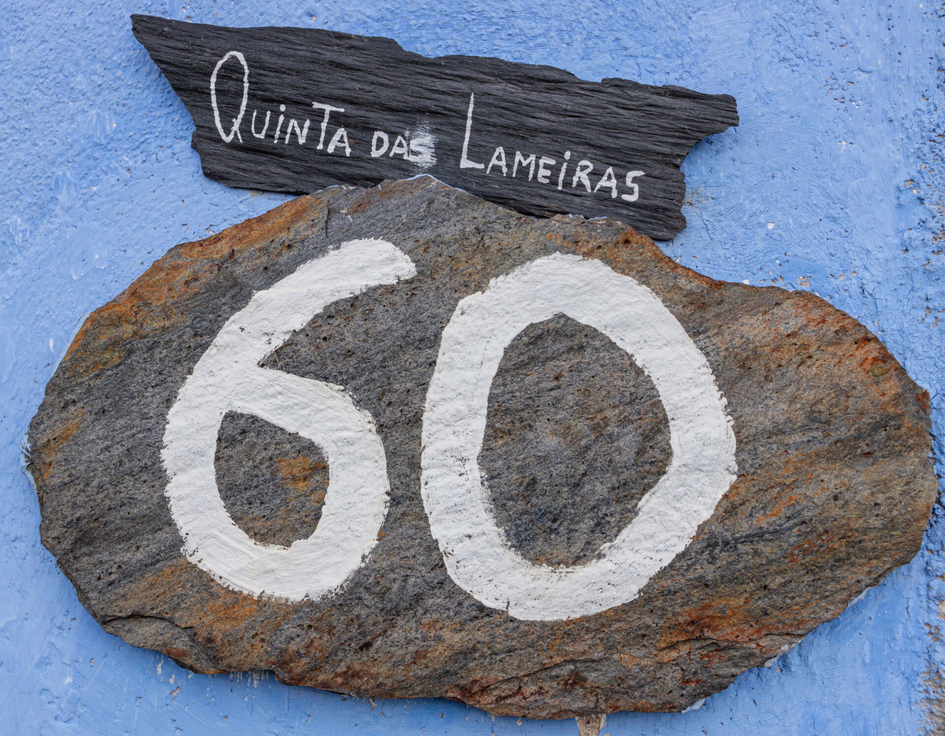 Number 60 written on a stone with a blue background