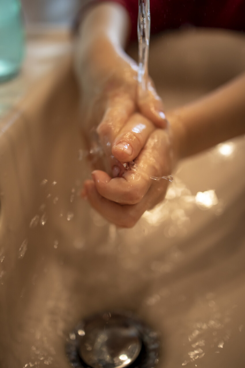 child is washing hands with soap