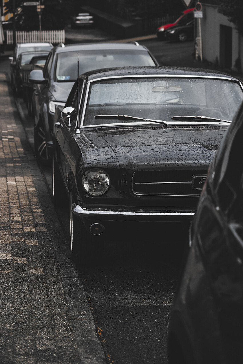 oldtimer ford mustang wet in a parking slot