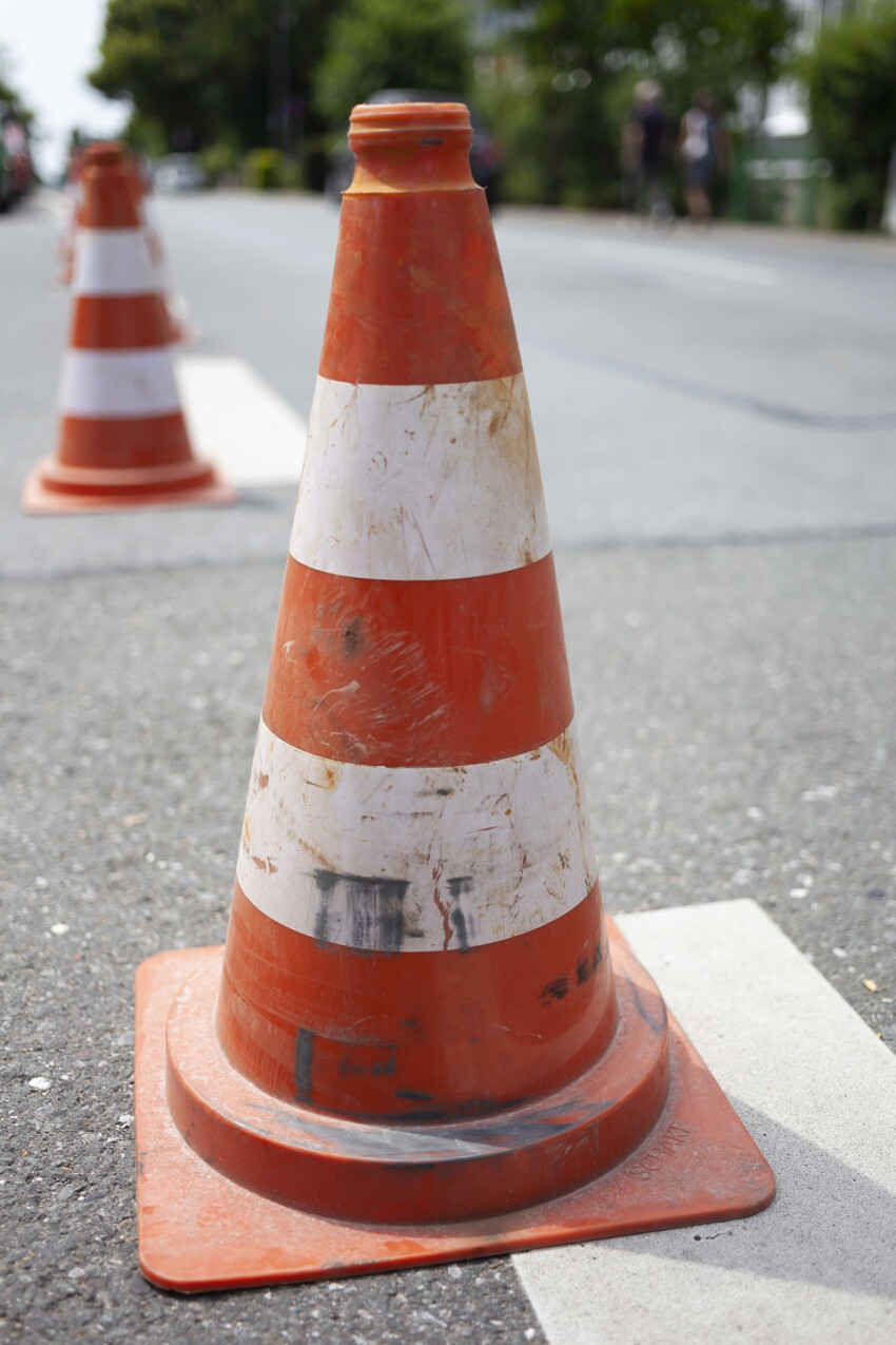 old striped cone on road