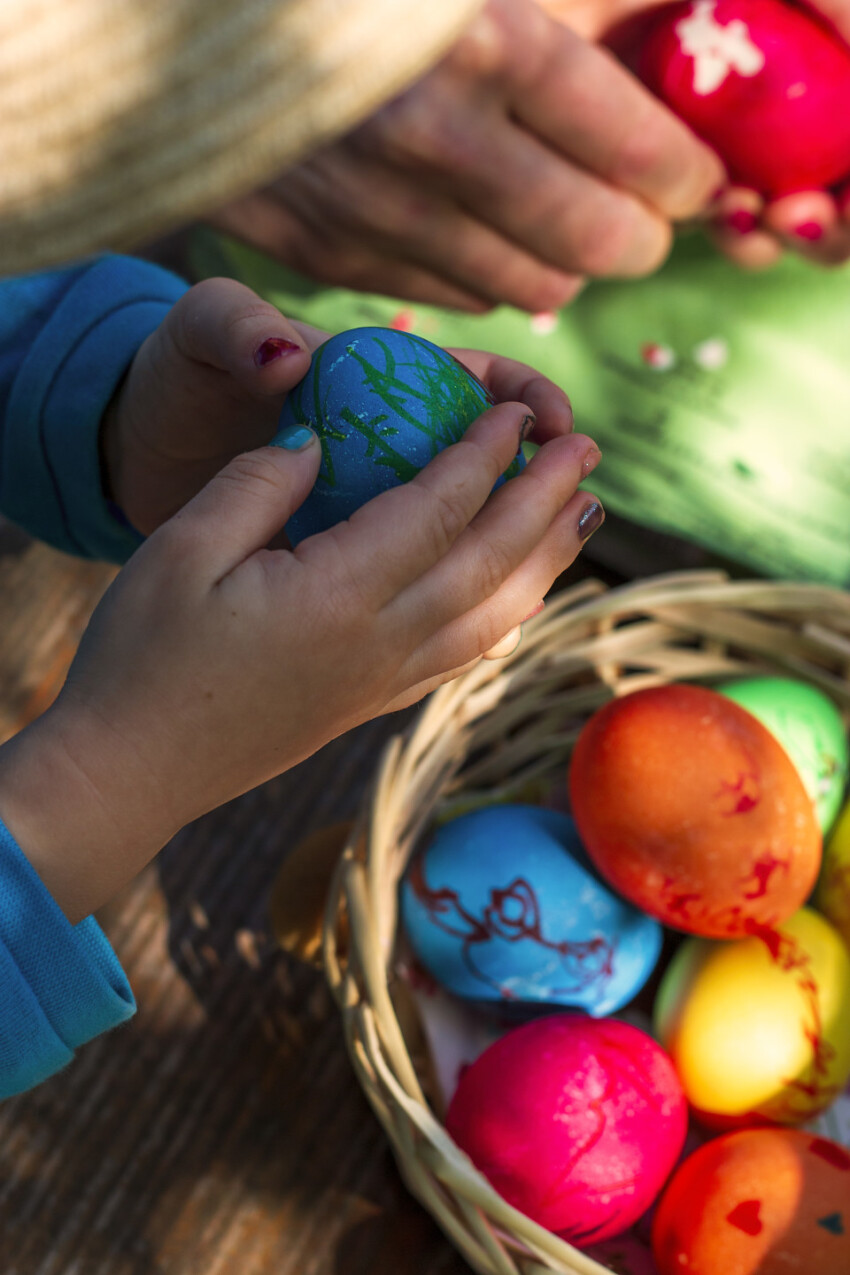 Children peel off the shell of colorful Easter eggs