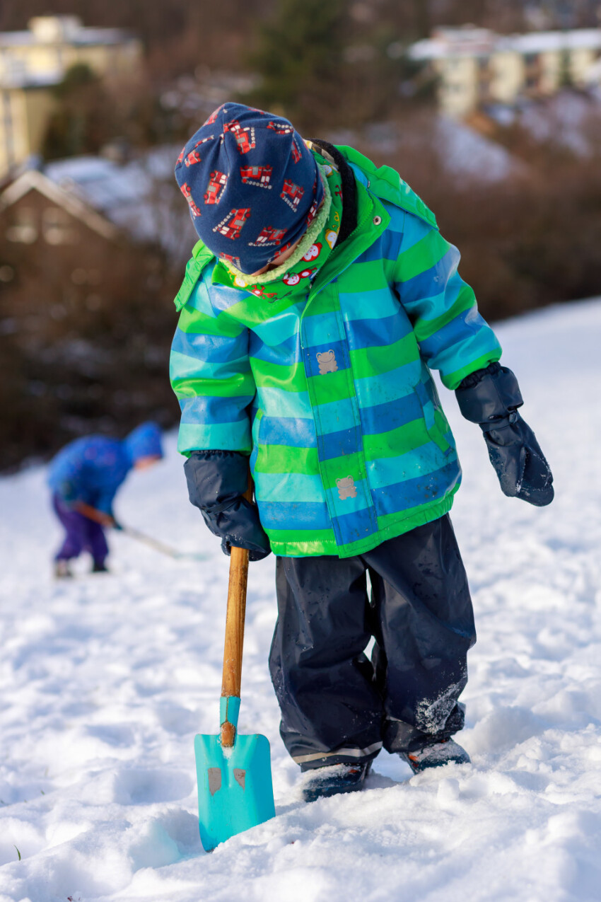 Little boy shovels snow