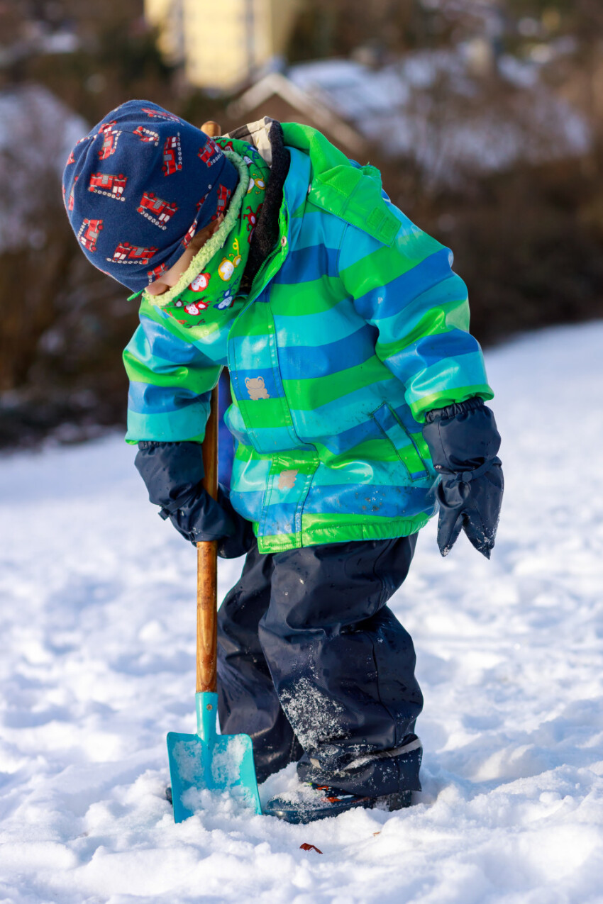 Little boy shovels snow