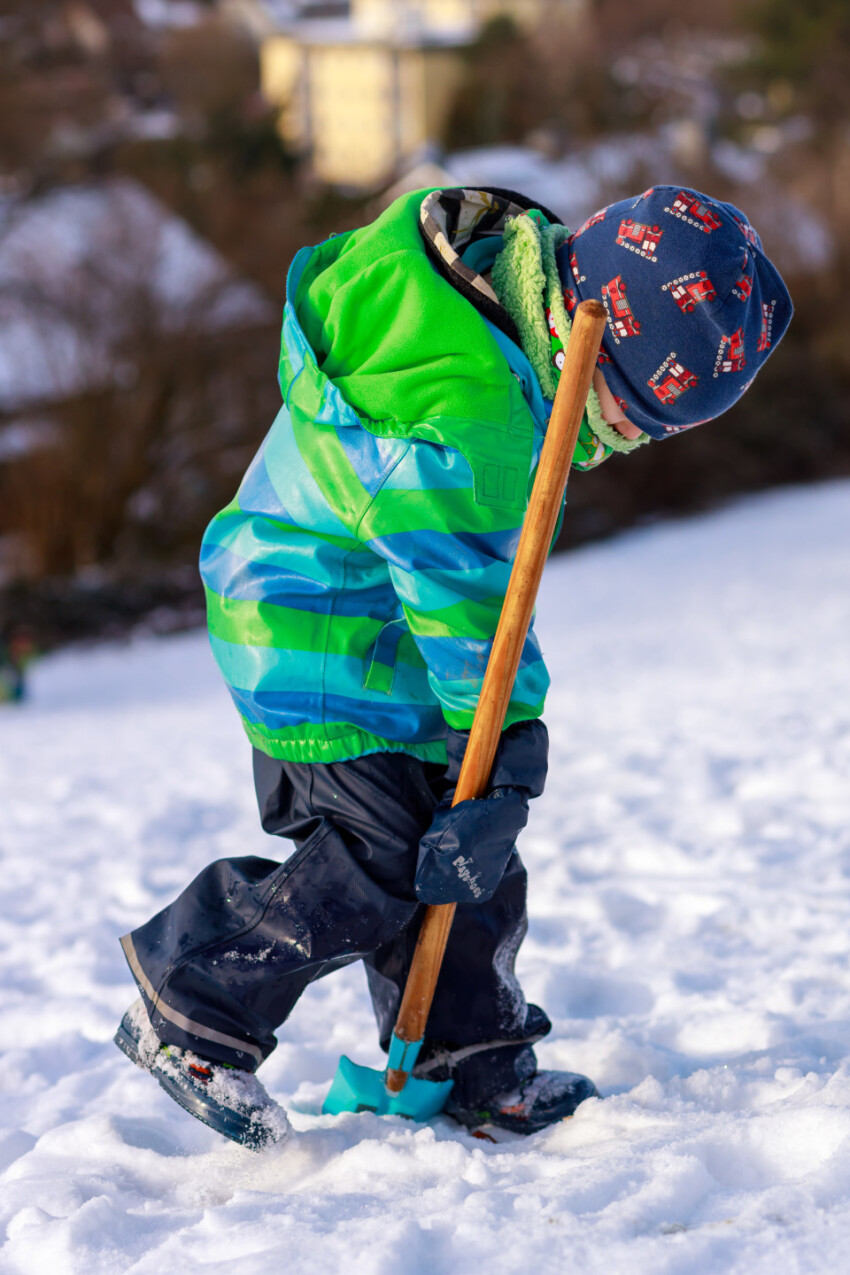 Little boy shovels snow