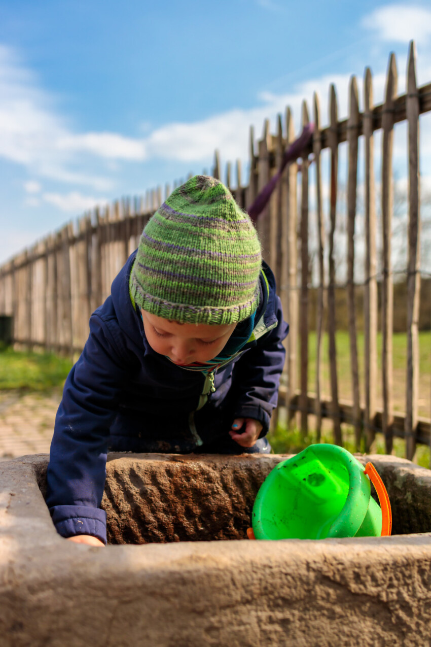 Toddler draws water from a well