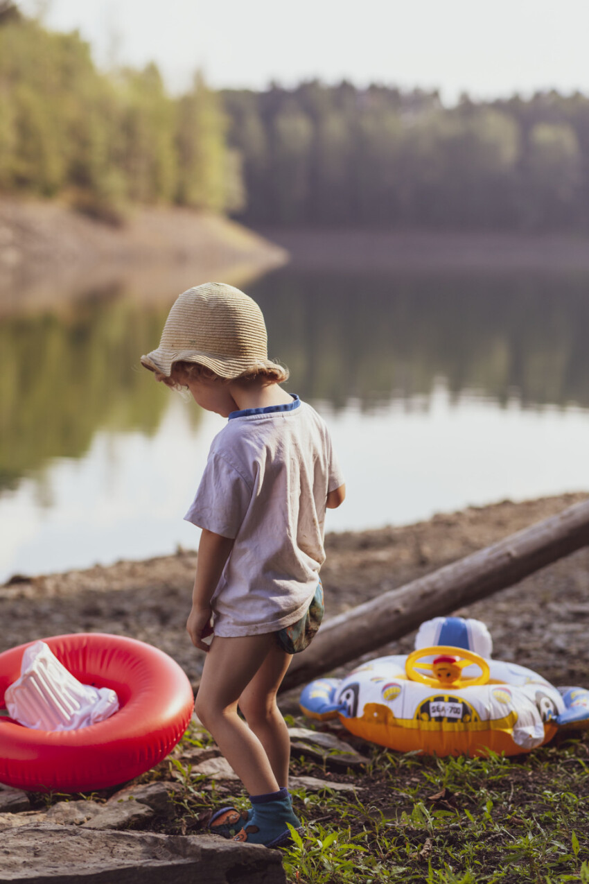 little boy on the beach of a lake