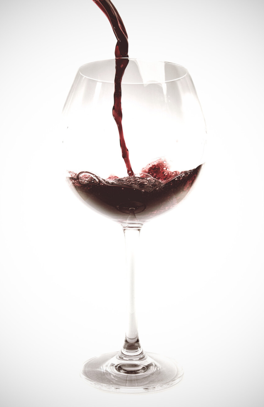Red wine is poured into a wine glass