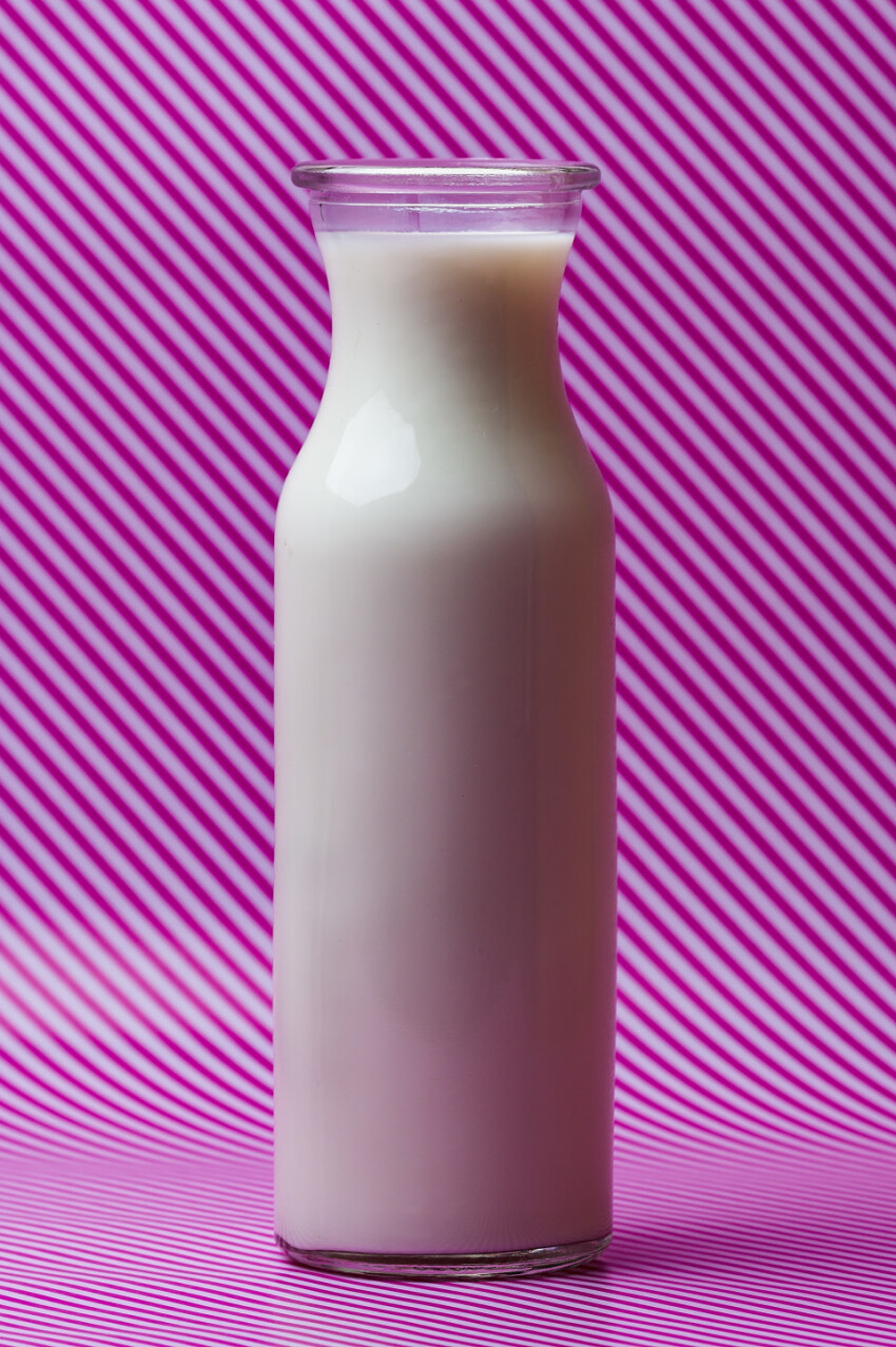 milk bottle on pink and white striped background
