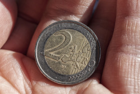 Stock Image: 2 euro coin with scratches in hand