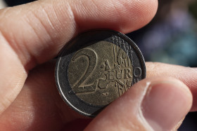 Stock Image: 2 euro coin with scratches in hand
