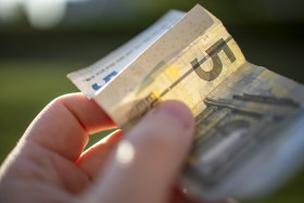 Stock Image: 5 euro banknotes in hand - pay with five euro
