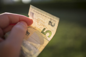 Stock Image: 5 euro banknotes in hand - pay with five euro