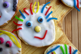 Stock Image: 84/5000 Cookies with icing decorated with colorful cute faces baked by children