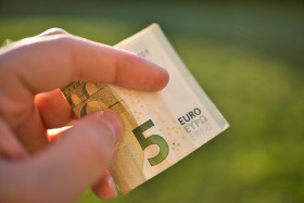 Stock Image: A new 5 Euro bank note in a human hand