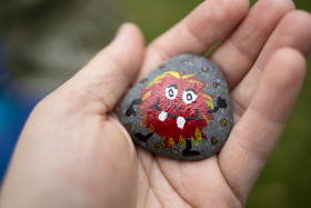 Stock Image: A stone on which a child has painted a red monster in a hand