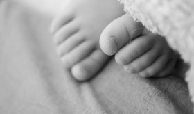 Stock Image: A toddler's toes peek out from under the blanket