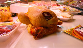 Stock Image: A whole roast chicken with head from the market