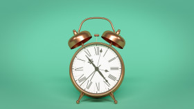 Stock Image: alarm clock isolated on green background