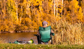 Stock Image: Angler sits by the lake