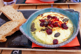 Stock Image: Baked goat cheese with cranberries and pumpkin seeds