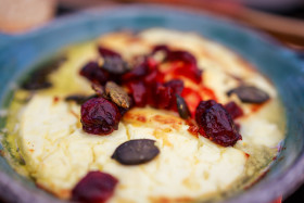 Stock Image: Baked goat cheese with cranberries and pumpkin seeds