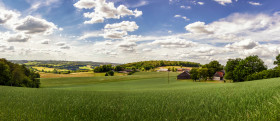 Stock Image: Beautiful rural landscape panorama in Germany with blue sky, impressive clouds and a wonderful little farm