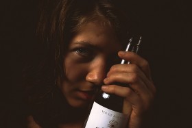 Stock Image: Beautiful young woman with bottle of wine