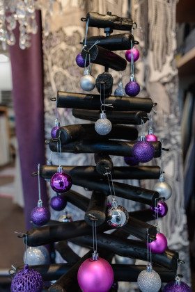 Stock Image: Black modern Christmas tree decorated with pink and purple balls