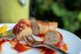 Stock Image: Bratwurst pieces pierced with a fork